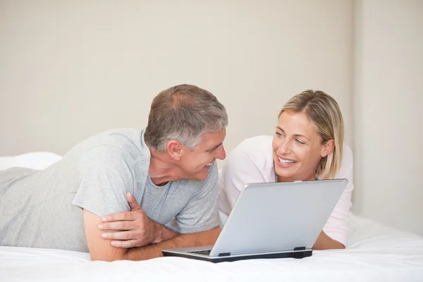 Прекрасна пара дивиться на свій ноутбук — стокове фото