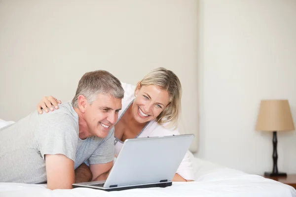 Lovely couple looking at their laptop — Stock Photo, Image