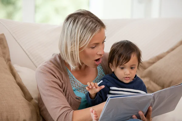 Mãe olhando para um livro com seu filho — Fotografia de Stock