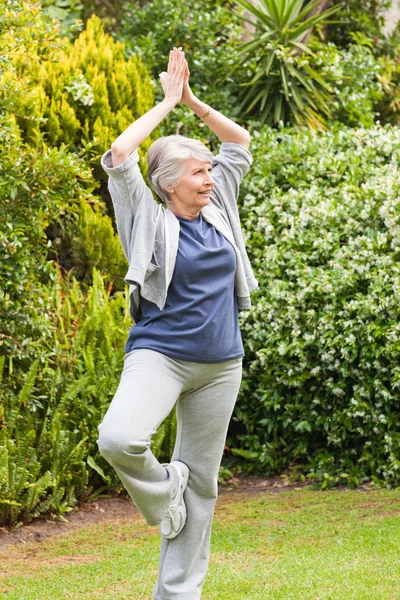 Volwassen vrouw doet haar spannen in de tuin — Stockfoto
