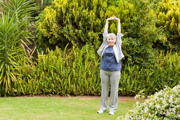 Donna in pensione che fa le sue streches in giardino — Foto Stock