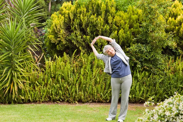 Συνταξιούχος γυναίκα κάνει της απλώνεται στον κήπο — Φωτογραφία Αρχείου
