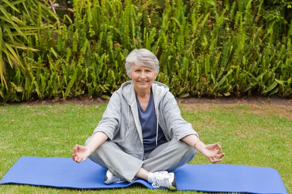 Mujer jubilada practicando yoga en el jardín —  Fotos de Stock