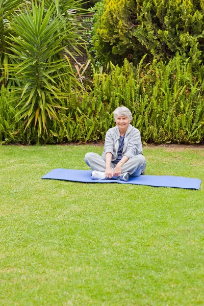 Mujer mayor haciendo sus streches en el jardín — Foto de Stock