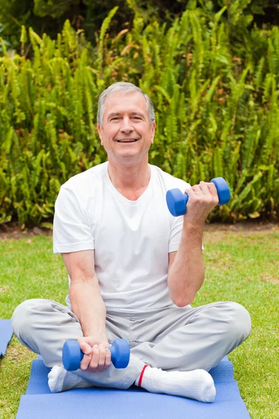 Homem aposentado fazendo seus exercícios no jardim — Fotografia de Stock