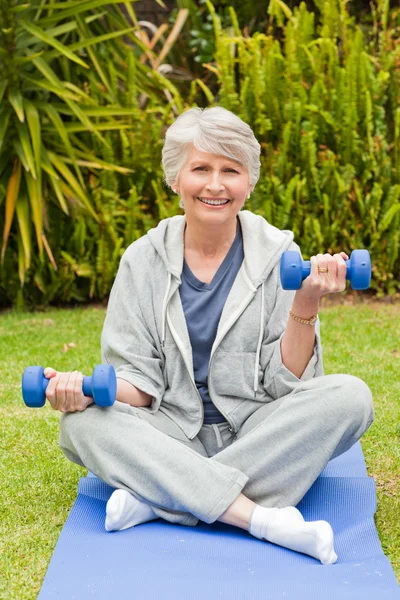 Mulher aposentada fazendo seus exercícios no jardim — Fotografia de Stock
