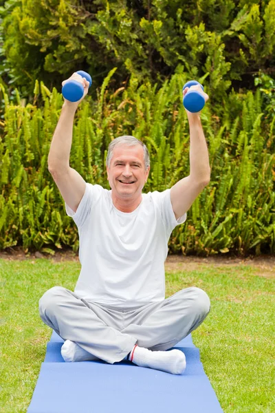 Retired man doing his exercises in the garden — Stock Photo, Image