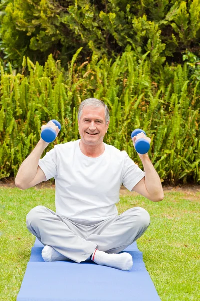 Hombre retirado haciendo sus ejercicios en el jardín —  Fotos de Stock