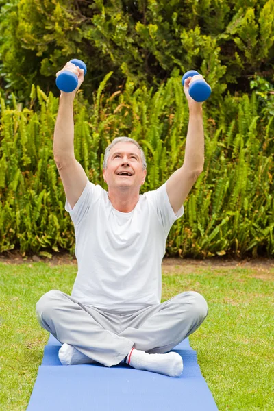 Homem aposentado fazendo seus exercícios no jardim — Fotografia de Stock