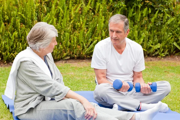Äldre par gör sina övningar i trädgården — Stockfoto
