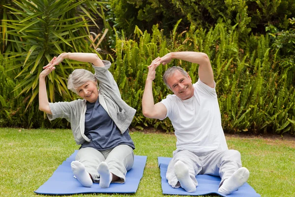 Seniorenpaar treibt seine Runden im Garten — Stockfoto