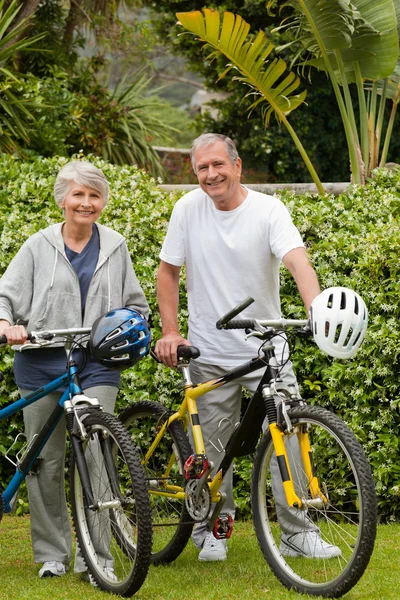 Äldre par promenader med sina cyklar — Stockfoto