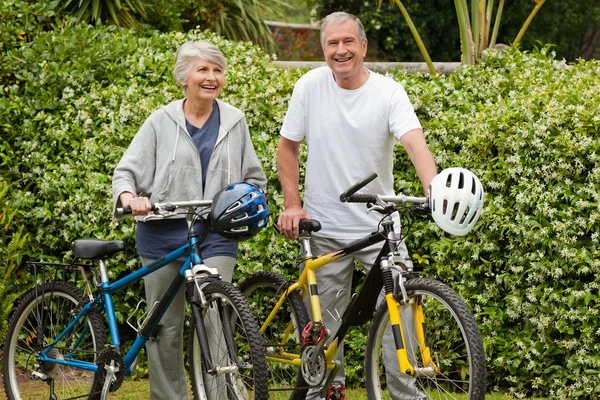 Äldre par promenader med sina cyklar — Stockfoto