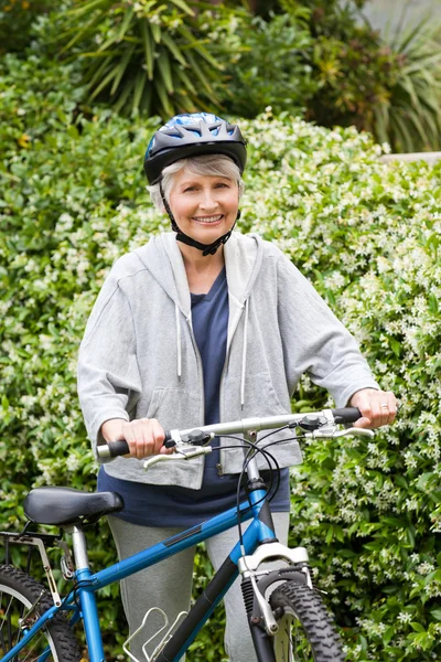 Olgun kadın dağ bisikleti ile yürüyüş — Stok fotoğraf