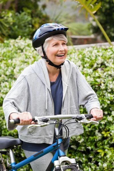 Mogen kvinna gå med sin mountainbike — Stockfoto