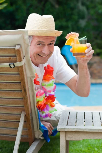 Érett ember iszik egy koktélt a medence mellett — Stock Fotó