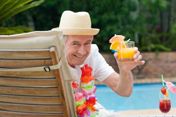 Homem maduro bebendo um coquetel ao lado da piscina — Fotografia de Stock