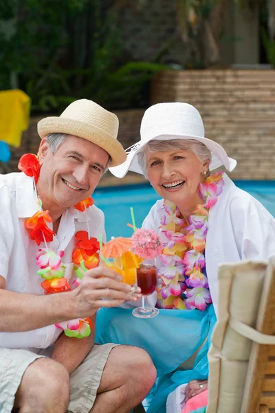 Счастливая старшая пара пьет коктейль и тосты друг за друга — стоковое фото