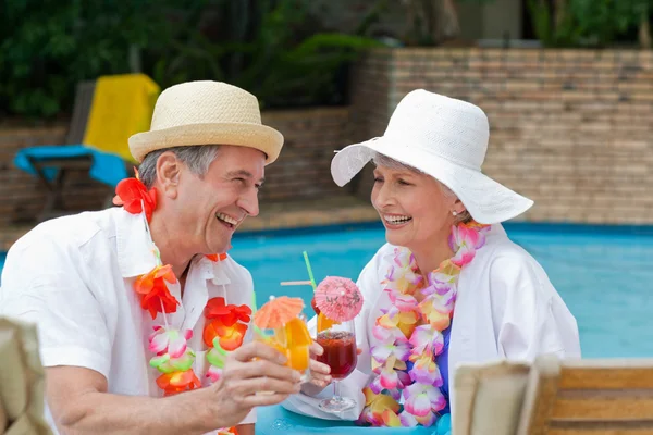 Glückliches Seniorenpaar trinkt Cocktails und prostet sich zu — Stockfoto