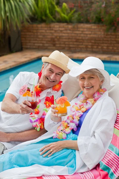 Érett pár iszik egy koktélt a medence mellett — Stock Fotó