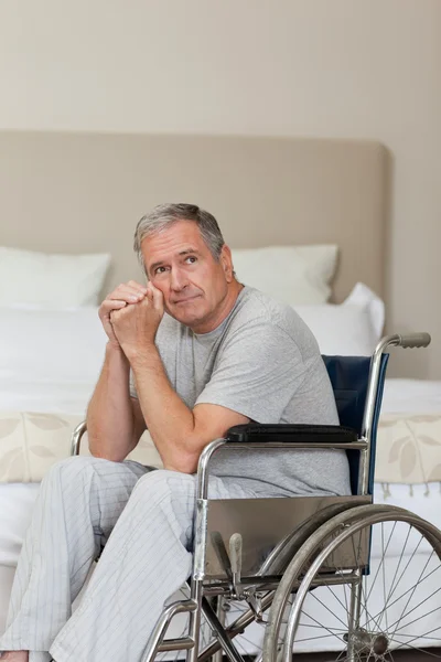 Homem idoso atencioso em sua cadeira de rodas — Fotografia de Stock