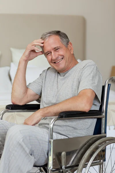 Homme âgé souriant dans son fauteuil roulant à la maison — Photo