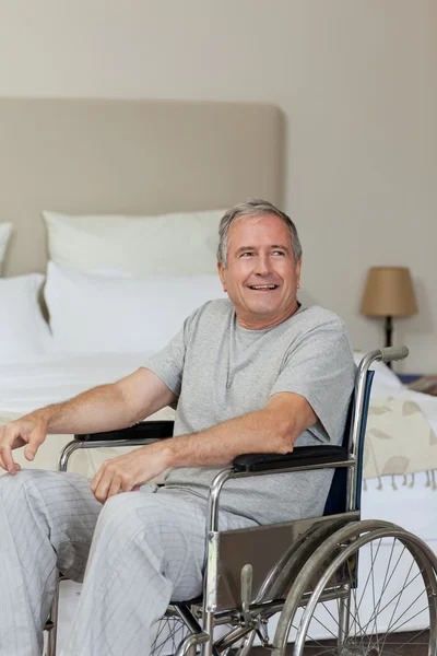 微笑在家里他坐轮椅的老人 — 图库照片
