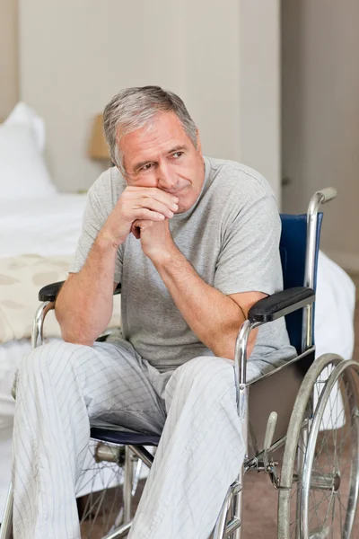 Lachende senior man in zijn rolstoel thuis — Stockfoto