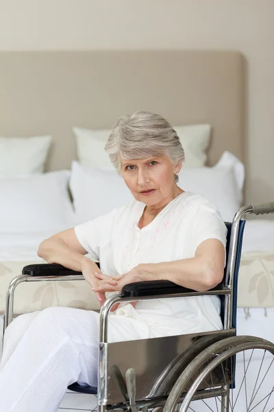Geconcentreerde senior vrouw in haar rolstoel thuis — Stockfoto