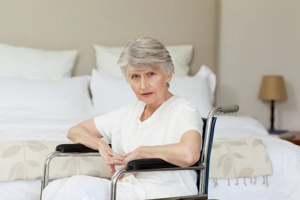Koncentrované starší žena v křesle doma — Stock fotografie