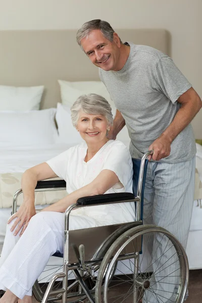 Pensionerad kvinna i hennes rullstol med maken — Stockfoto