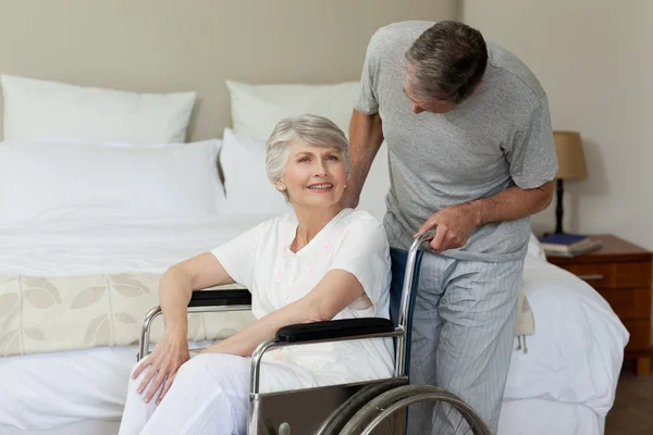 Mujer jubilada en silla de ruedas con su marido — Foto de Stock