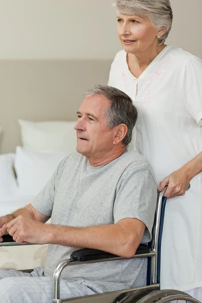 Retired man in his wheelchair with his wife — Stock Photo, Image