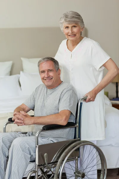Retired man in his wheelchair with his wife — Stock Photo, Image