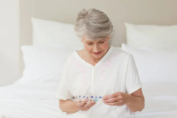 Sick senior woman taking her pills — Stock Photo, Image