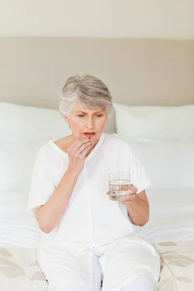 Chory starszy kobieta przy jej tabletki — Zdjęcie stockowe