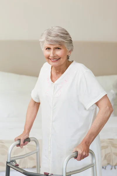 Äldre kvinna med hennes zimmer ram — Stockfoto