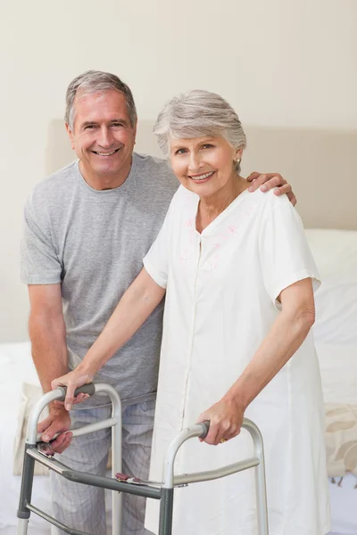 Man helping his wife to walk — Stock Photo, Image