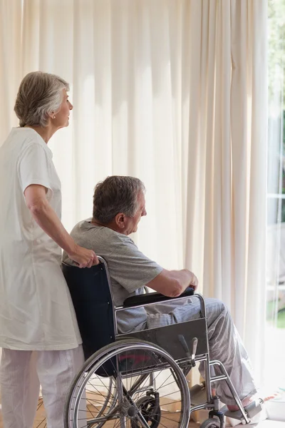 Пара пенсионеров смотрит в окно — стоковое фото