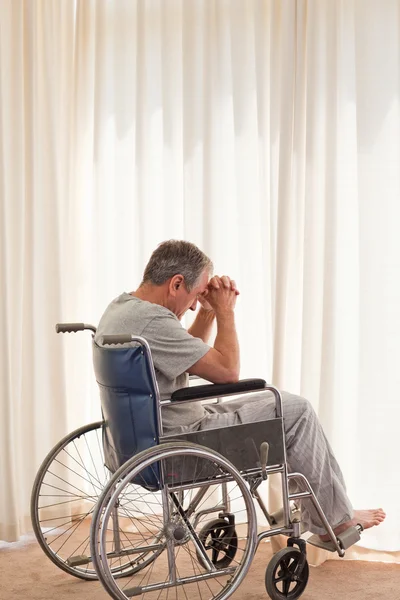 Homme réfléchi dans son fauteuil roulant — Photo