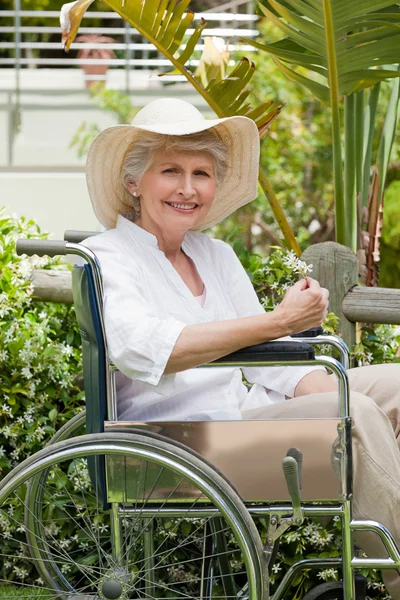 Femme mûre dans son fauteuil roulant dans le jardin — Photo