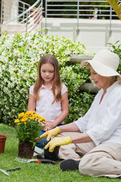 Grootmoeder met haar kleindochter die in de tuin werkt — Stockfoto