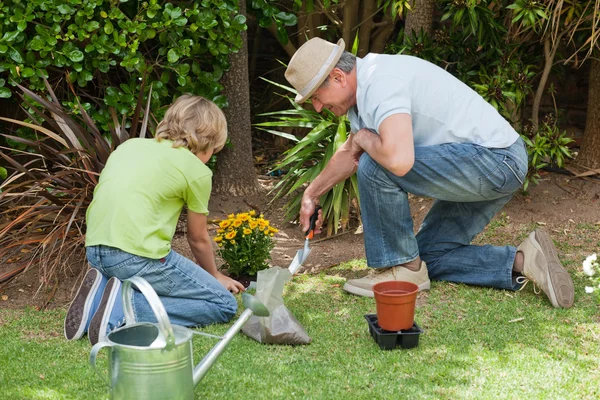 Abuelo con su nieto trabajando en el jardín — Foto de Stock