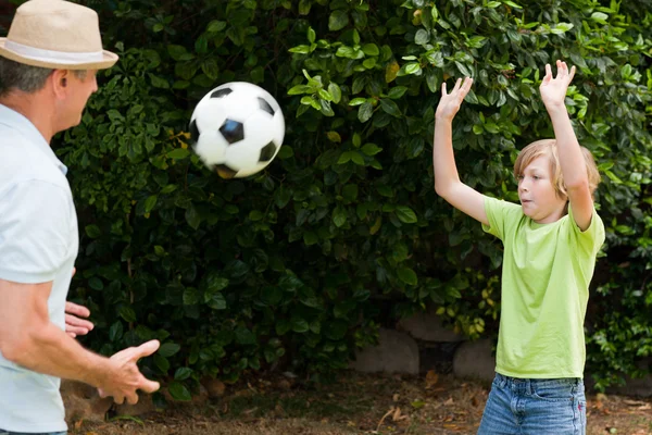 Farfar och hans sonson spela fotboll — Stockfoto