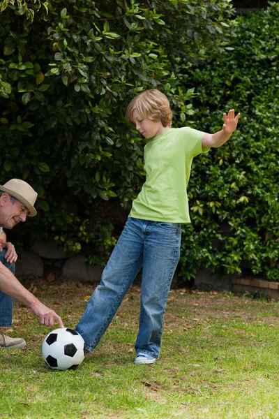 Grootvader en zijn kleinzoon voetballen — Stockfoto
