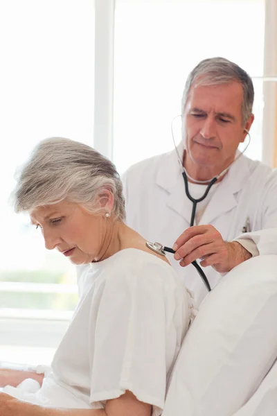 Senior doctor taking the heartbeat of his patient — Stock Photo, Image