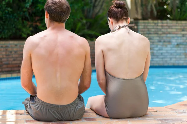 Paar zitten naast het zwembad — Stockfoto