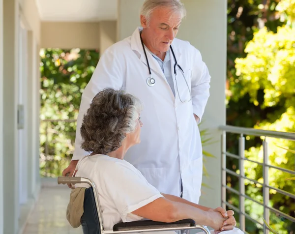 Doutor com seu paciente em sua cadeira de rodas — Fotografia de Stock