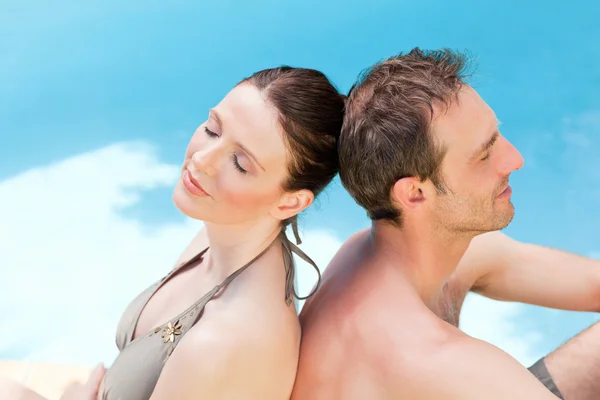 Paar sitzt am Pool Rücken an Rücken — Stockfoto