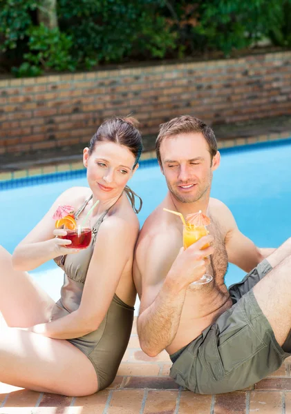 Couple drinking cocktails back to back — Stock Photo, Image